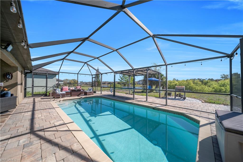 Outdoor pool featuring a lanai, a sunroom, a patio, and outdoor furniture