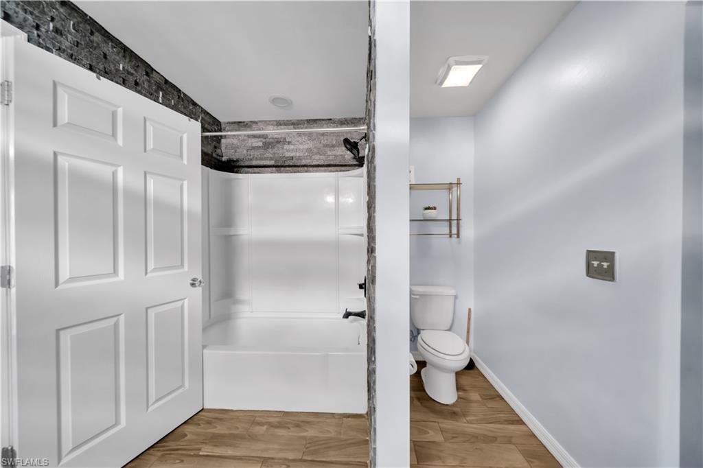Bathroom featuring light wood-type flooring and shower / bathtub combination