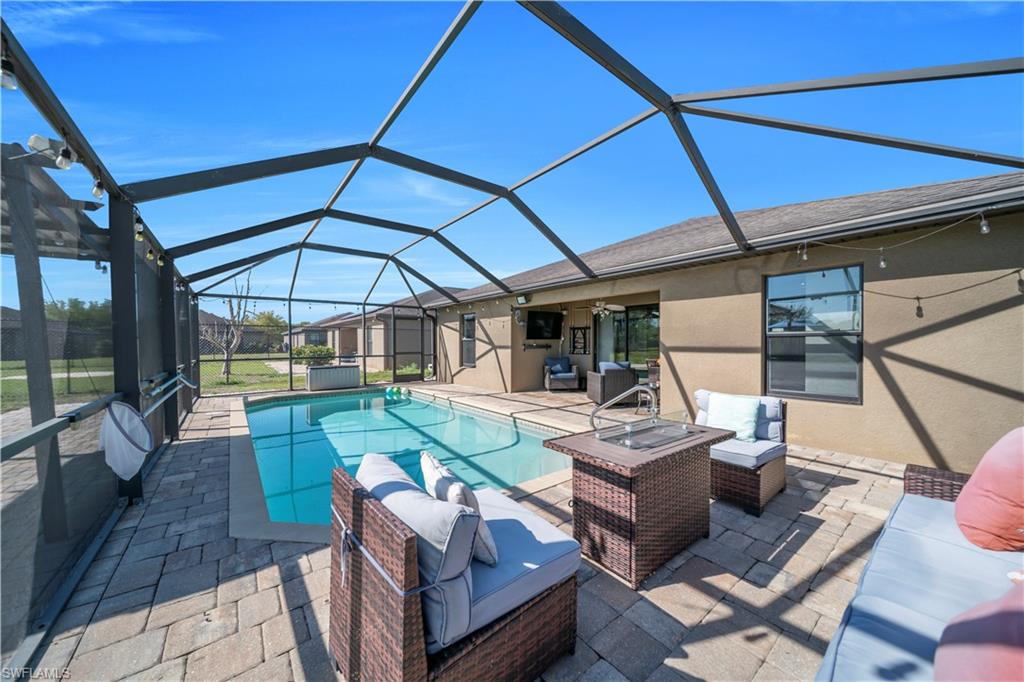 Swimming pool with outdoor lounge area, a patio, a sunroom, and glass enclosure
