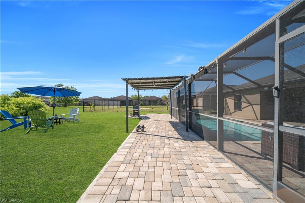 Fenced backyard featuring a patio, a lanai, an outdoor pool, and a sunroom