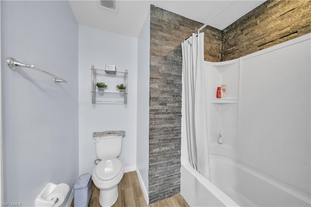 Bathroom featuring light wood-style floors and shower / tub combo