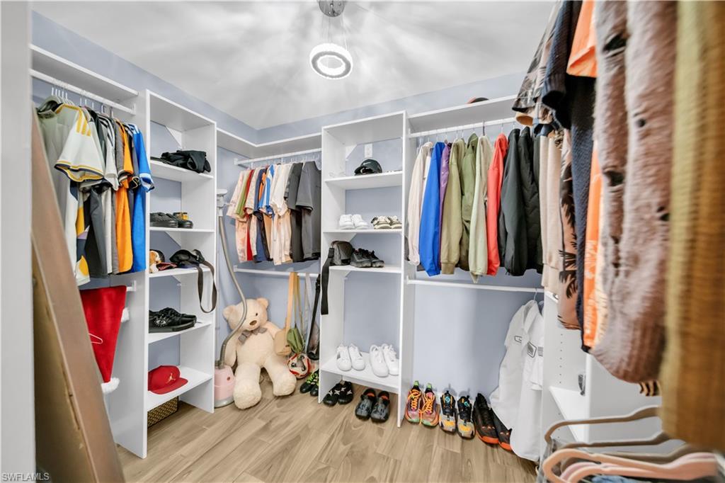 Walk in closet with light wood finished floors
