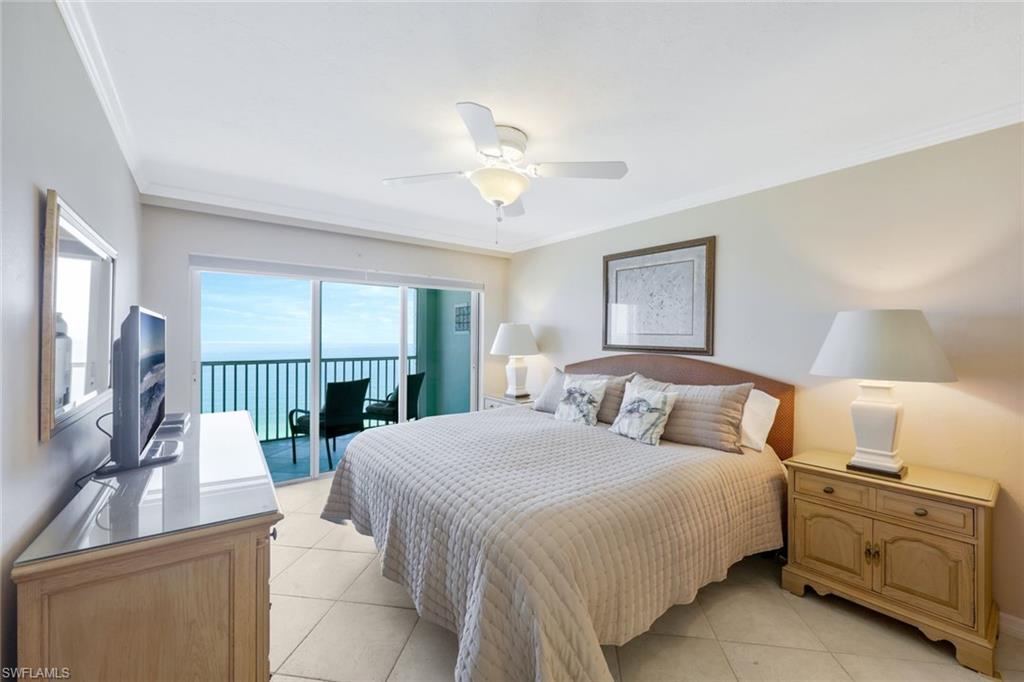 Tiled bedroom with a water view, ornamental molding, ceiling fan, and access to outside
