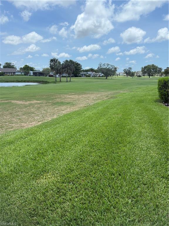 View of behind the home, featuring a view of the lake and golf course