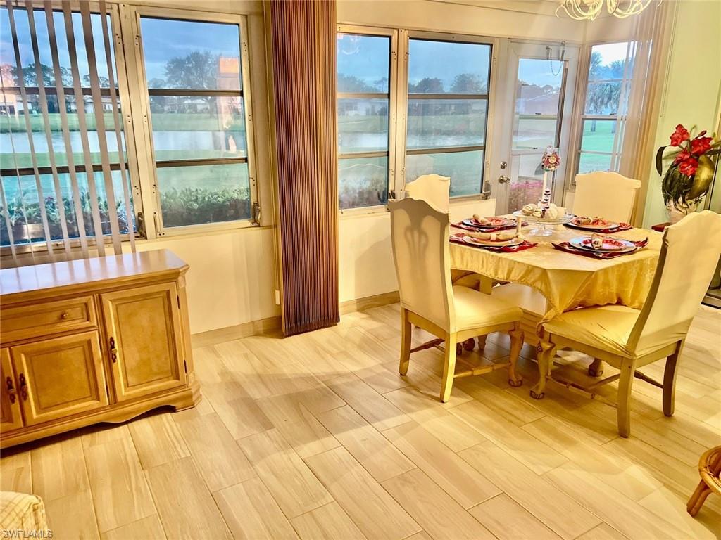Dining room with an inviting view of the lake and golf course, with light wood-like flooring