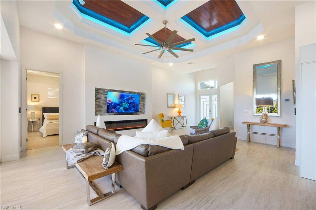Living area with coffered ceiling, recessed lighting, a ceiling fan, and light wood-style floors