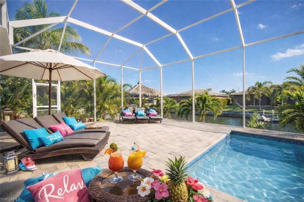 Outdoor pool with a lanai, a sunroom, a water view, and a patio area