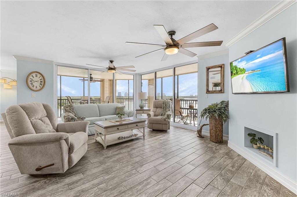 The spacious living room has tile that looks like wood, new impact glass sliders that open to the wrap-around lanai.