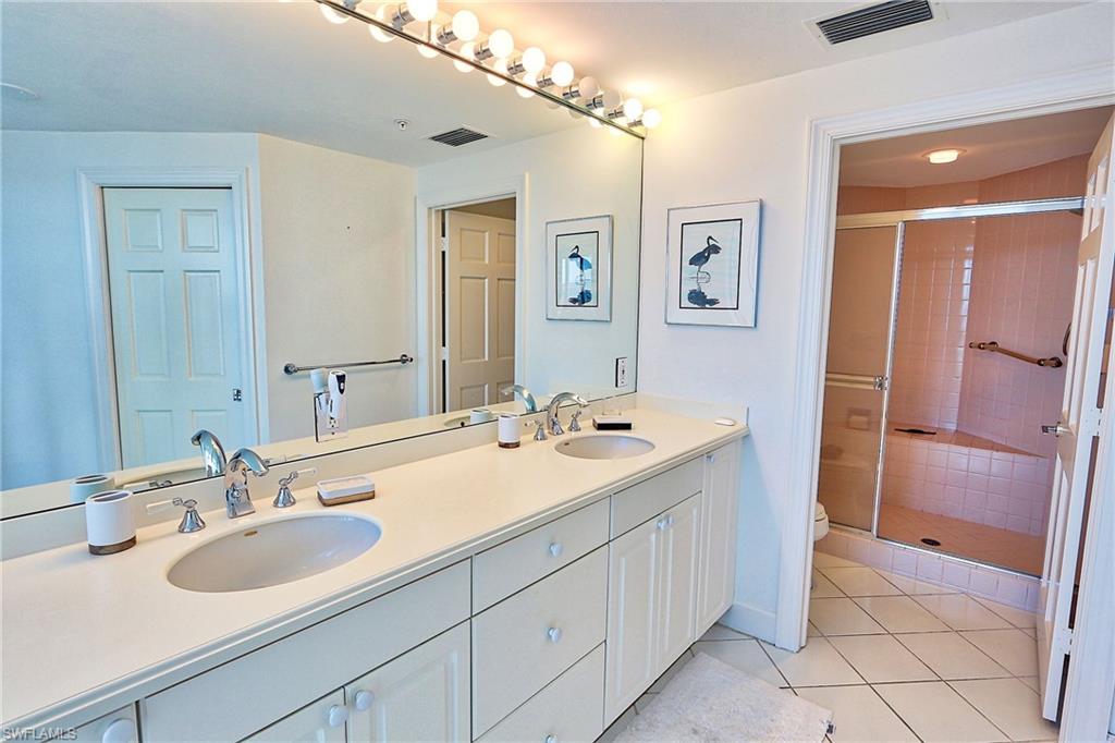 Bathroom with visible vents, a sink, and a shower stall