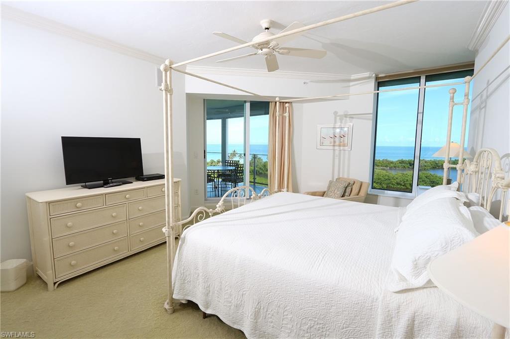 Bedroom with a water view, light colored carpet, access to outside, ceiling fan, and crown molding