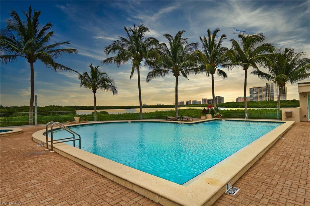 Pool at dusk with a patio area and a community pool