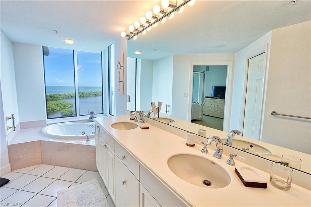 Bathroom with a bath, tile patterned floors, a sink, and double vanity