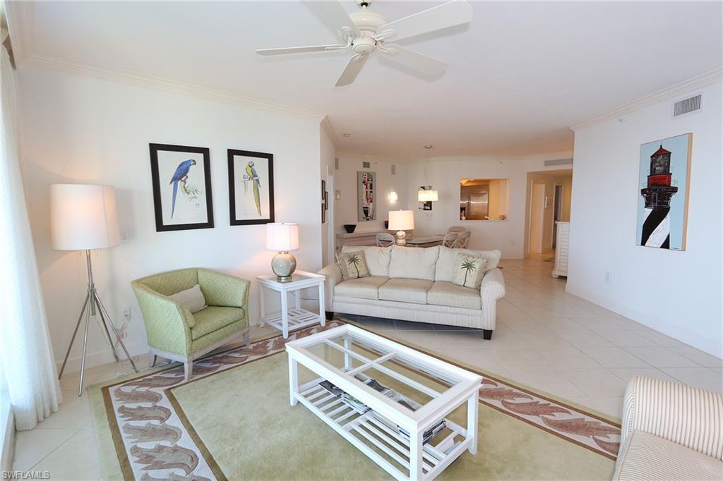 Living room with visible vents, crown molding, and light tile patterned floors