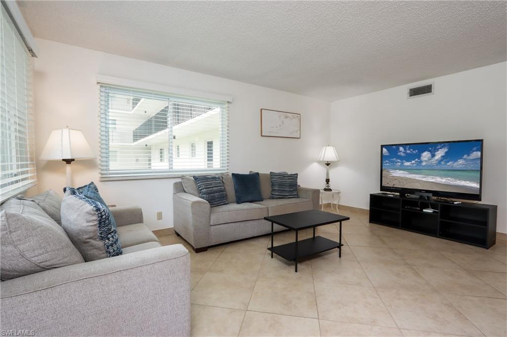 Living area with a textured ceiling and light tile patterned floors