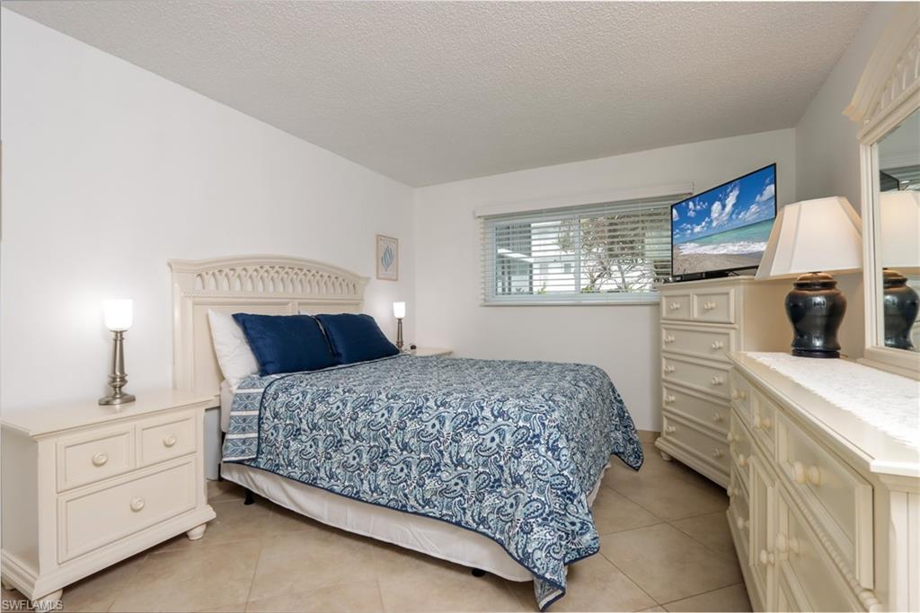 Bedroom featuring light tile patterned floors and a textured ceiling