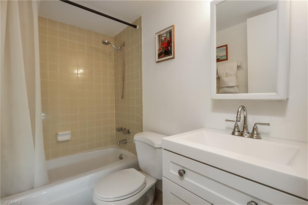 Bathroom featuring shower / tub combo with curtain and vanity