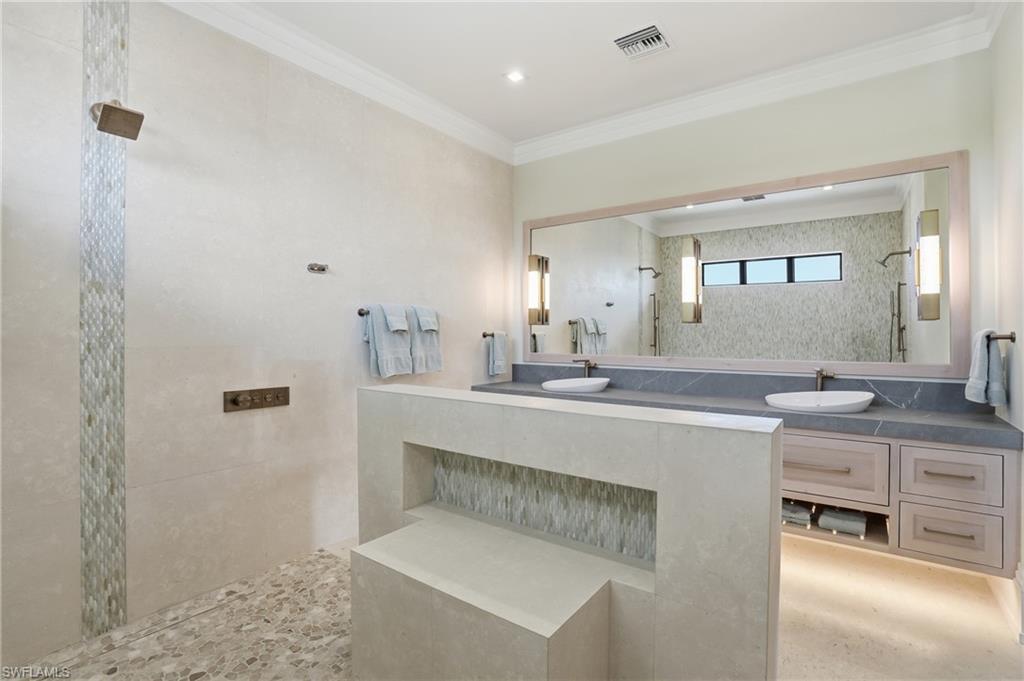 Bathroom featuring a walk in shower, ornamental molding, and vanity - Virtually Edited Image