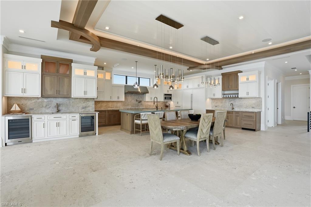 Dining room with ornamental molding, beverage cooler, a raised ceiling, and recessed lighting - Virtually Edited Image