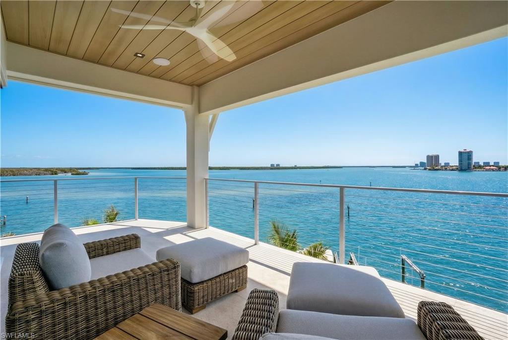 Balcony with a water view, a ceiling fan, and outdoor furniture - Virtually Edited Image