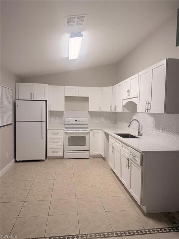 Contemporary kitchen featuring white cabinetry, light countertops, a herringbone tile backsplash, and ceramic tile flooring with a decorative border