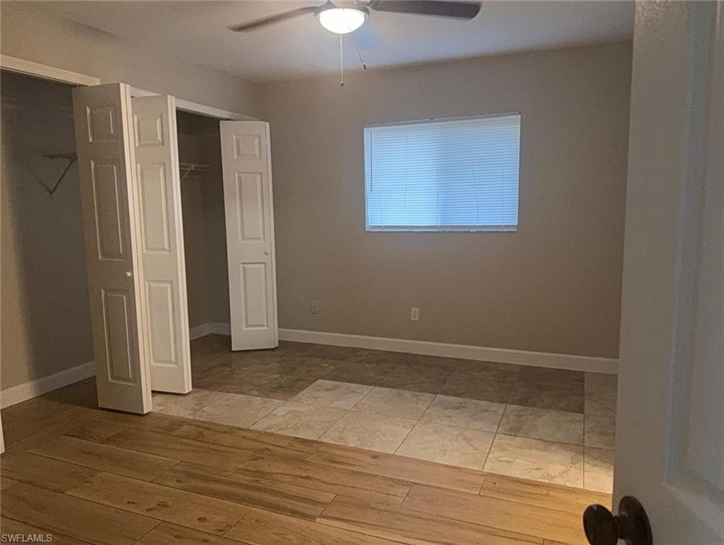 Interior room featuring wood-finish flooring transitioning to square tile flooring