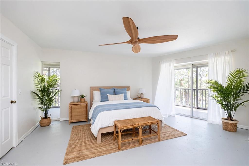 Virtually Staged Spacious room featuring a light wood-finish ceiling fan, smooth light-toned flooring, and a sliding glass door leading to an outdoor balcony