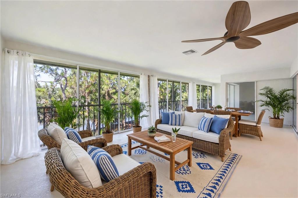 Virtually Staged Screened porch with wood-finish ceiling fan and expansive window walls