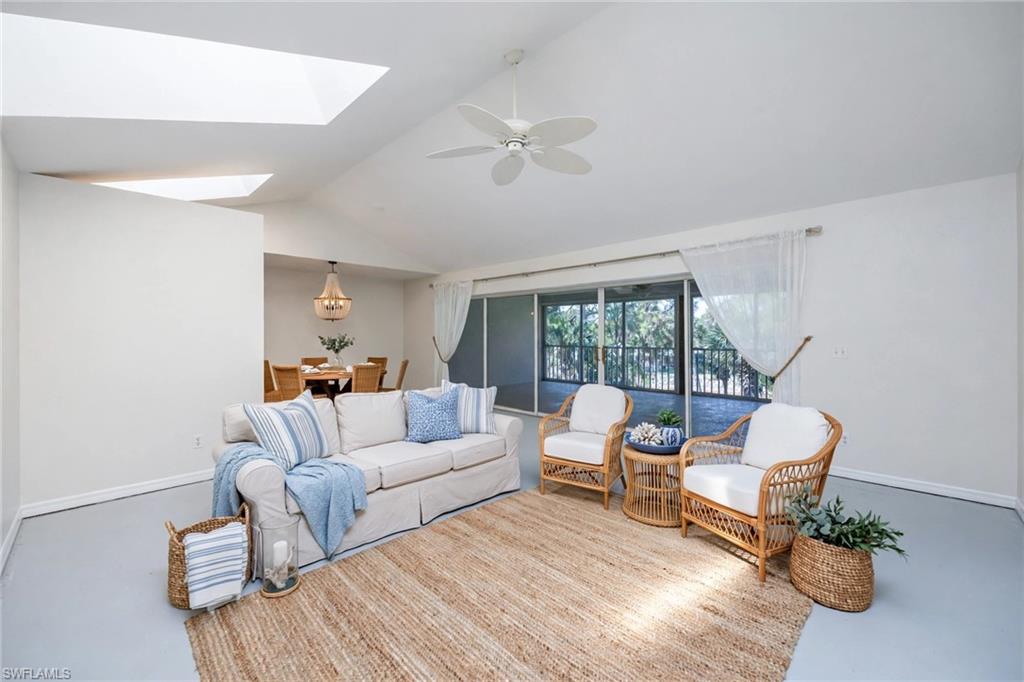 Virtually Staged Vaulted ceiling living space featuring multiple skylights, ceiling fan, and sliding glass doors