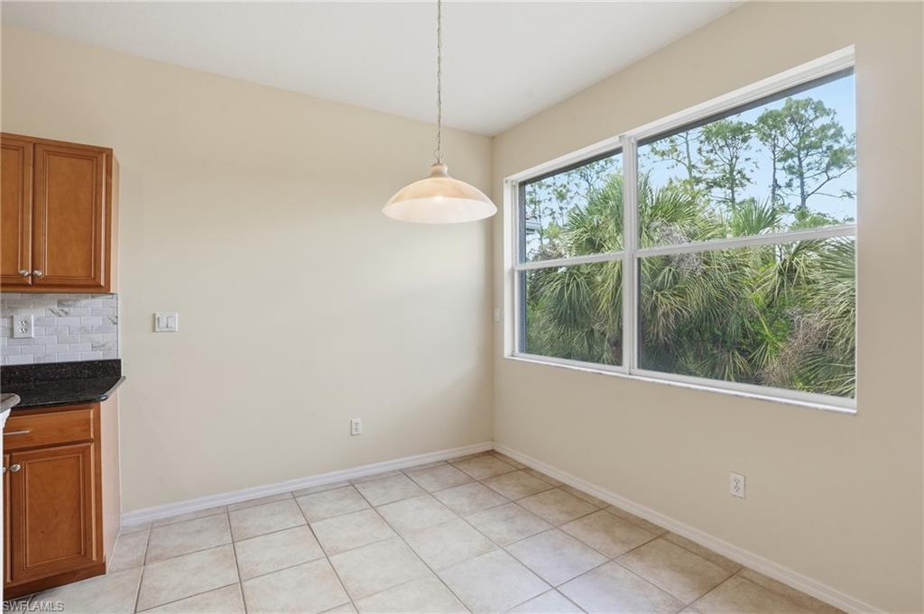 Unfurnished dining area featuring baseboards and light tile patterned flooring