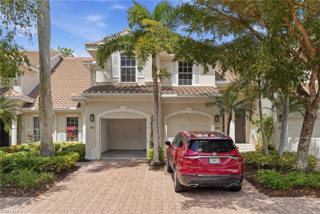 Mediterranean / spanish home with decorative driveway, a garage, and a tiled roof