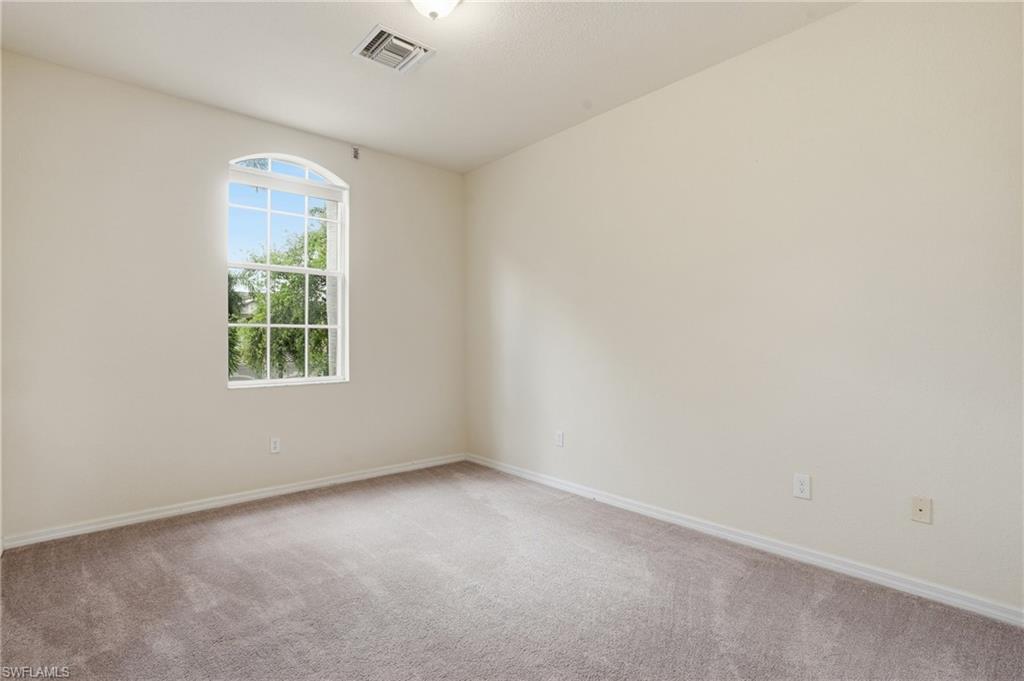Spare room featuring light colored carpet and baseboards
