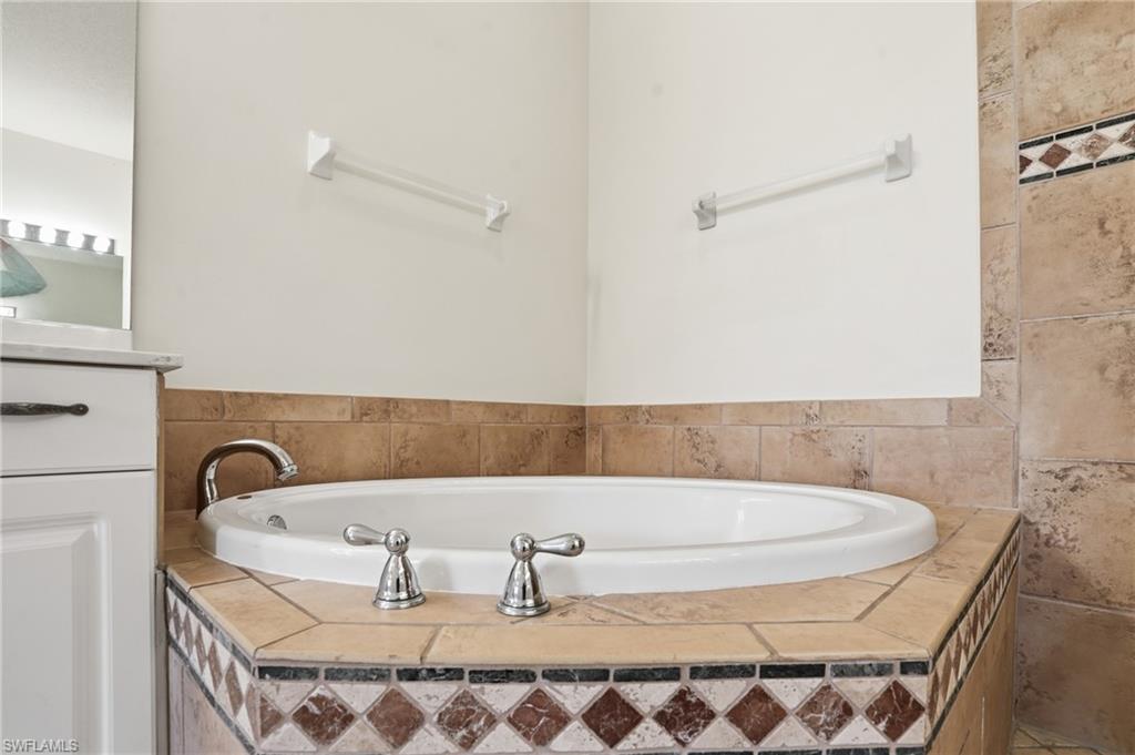 Full bathroom with a garden tub and vanity