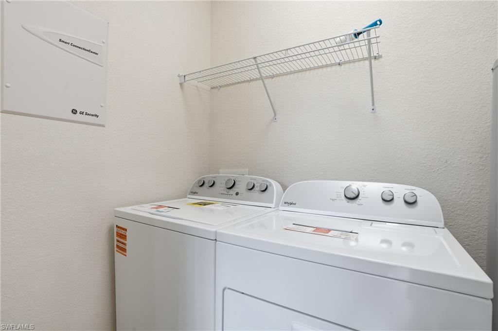 Laundry area with a textured wall and washing machine and dryer