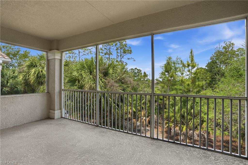 Unfurnished sunroom with a textured ceiling, a textured wall, and carpet