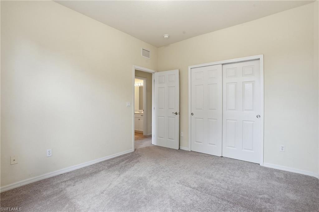 Unfurnished bedroom with light carpet and a closet