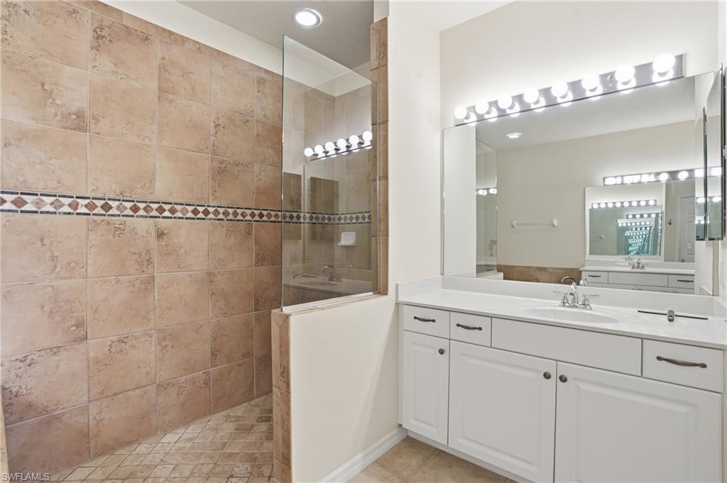 Bathroom with walk in shower, vanity, and recessed lighting