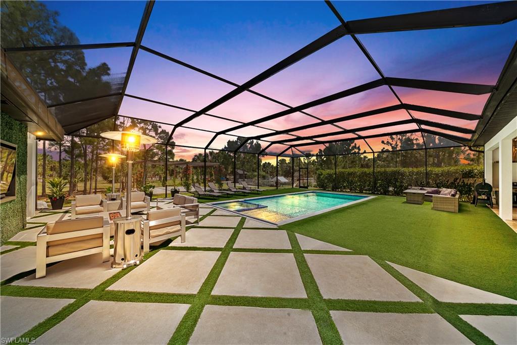 Swimming pool featuring an outdoor living space, a sunroom, a patio, and a lanai