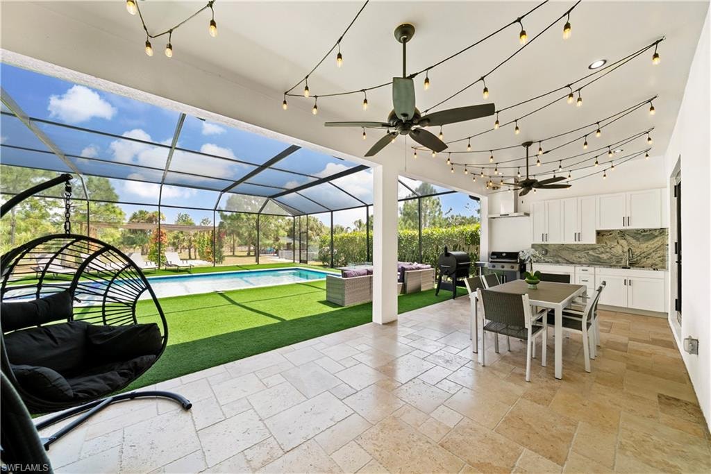 View of patio with a sunroom, an outdoor living / dining area, a ceiling fan, an outdoor pool, and a lanai
