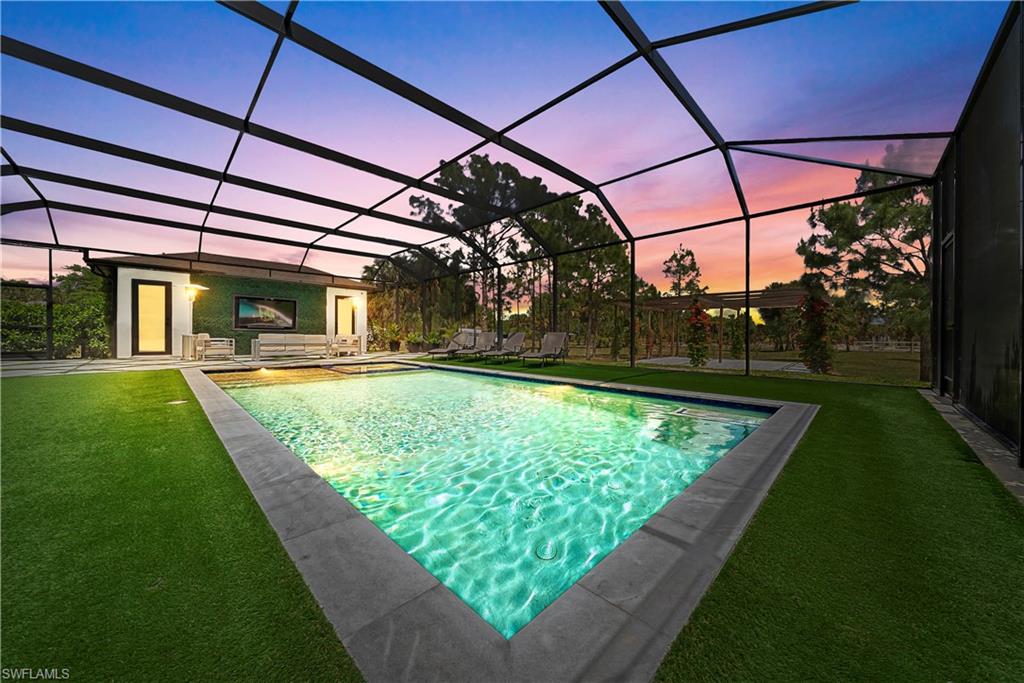 Swimming pool with a lawn, a lanai, and a sunroom