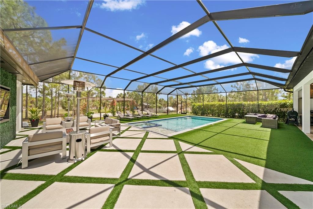 Integrated pool / hot tub with outdoor furniture, a sunroom, a patio area, and a lanai