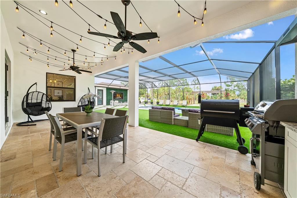 View of patio featuring a ceiling fan, a sunroom, an outdoor living / dining area, area for grilling, and a lanai