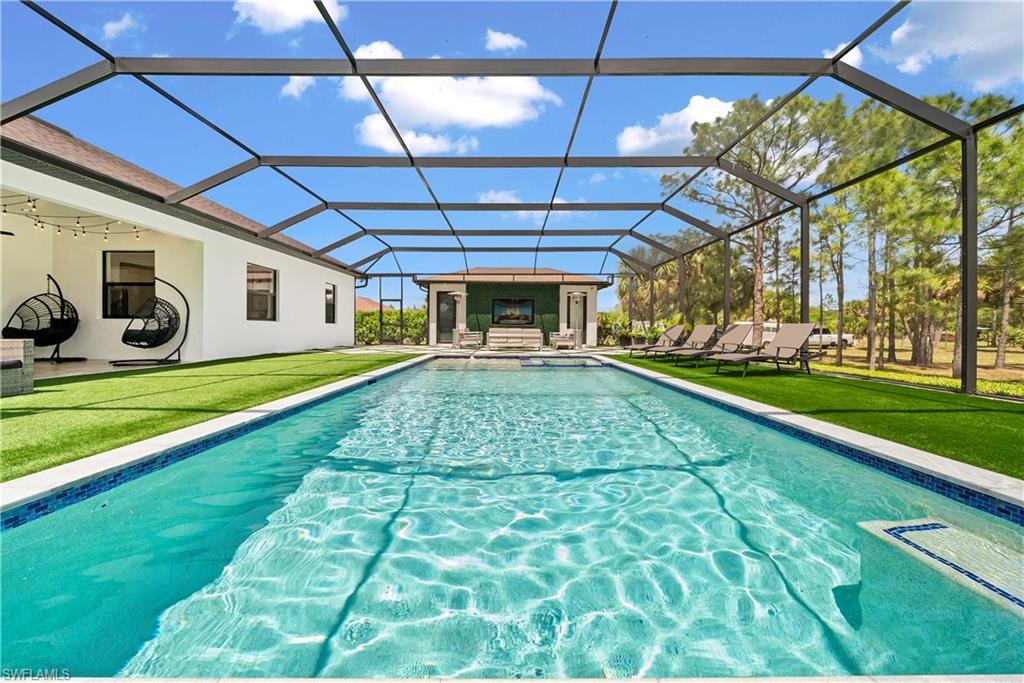 Outdoor pool with a yard, a sunroom, a patio area, and a lanai