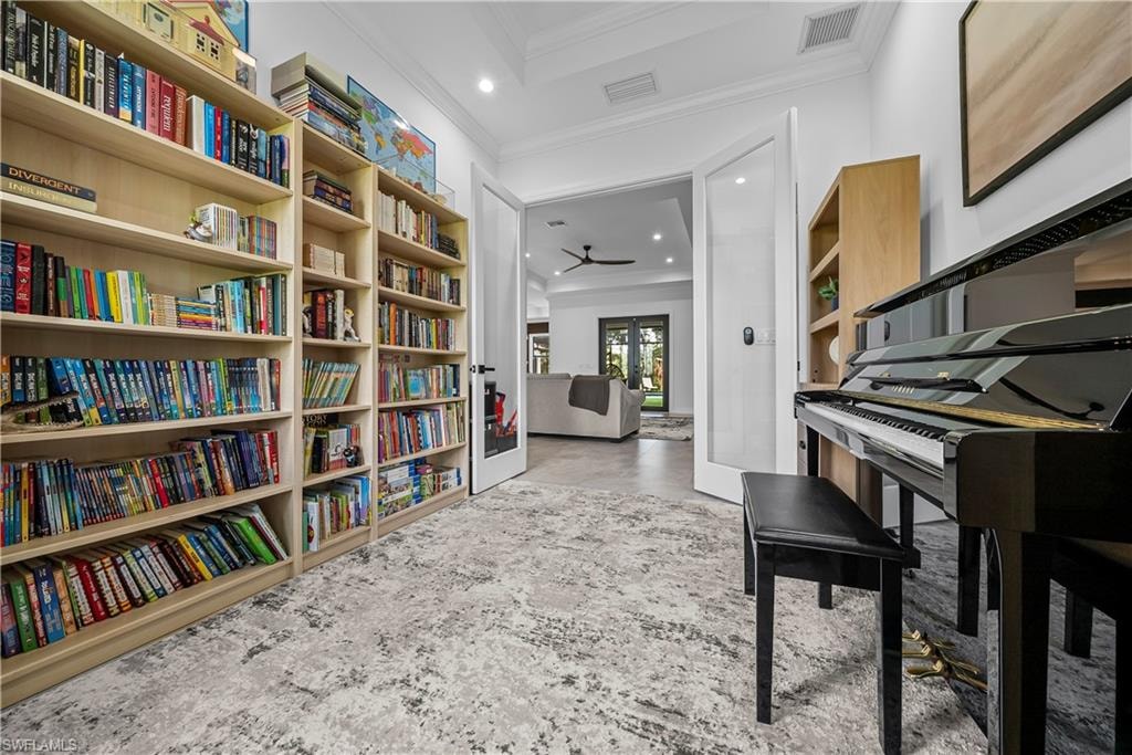Living area with ornamental molding, a ceiling fan, recessed lighting, and a tray ceiling