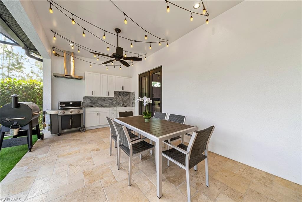 View of patio with an outdoor kitchen / dining area and ceiling fan