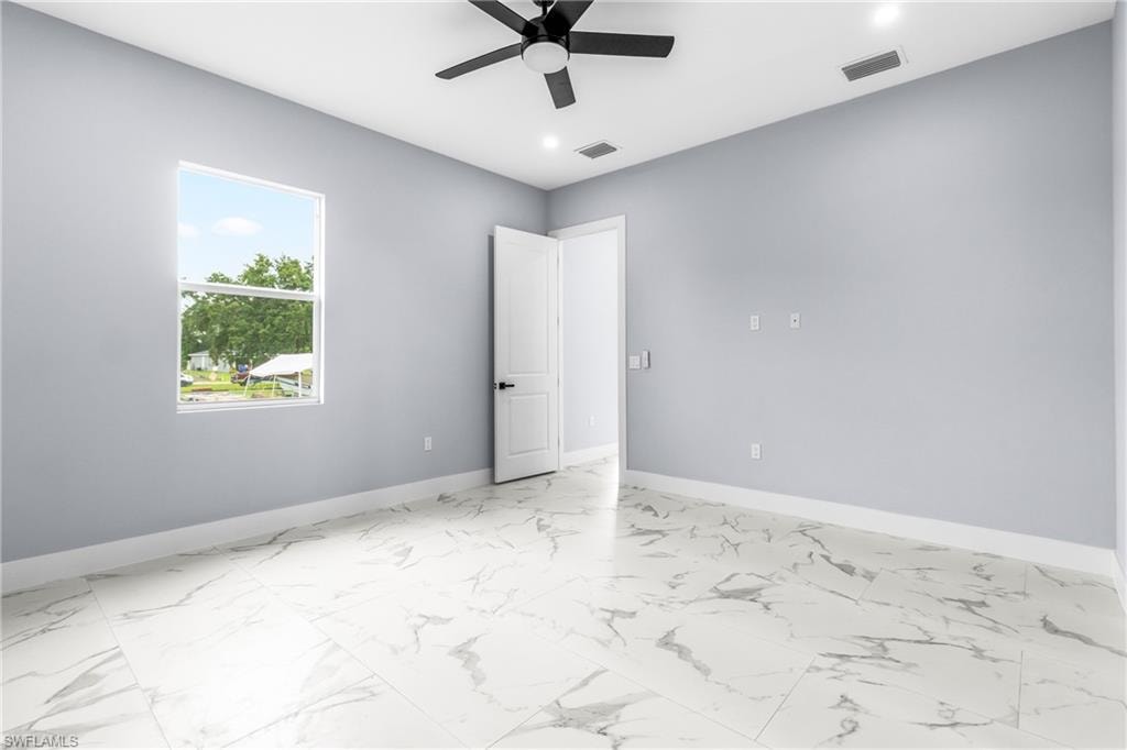 Spare room featuring light marble finish floors, a ceiling fan, and recessed lighting