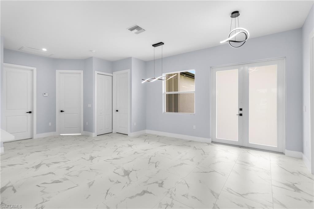 Spare room featuring french doors, light marble finish floors, and recessed lighting