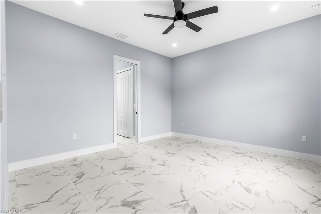 Spare room with light marble finish floors, a ceiling fan, and recessed lighting