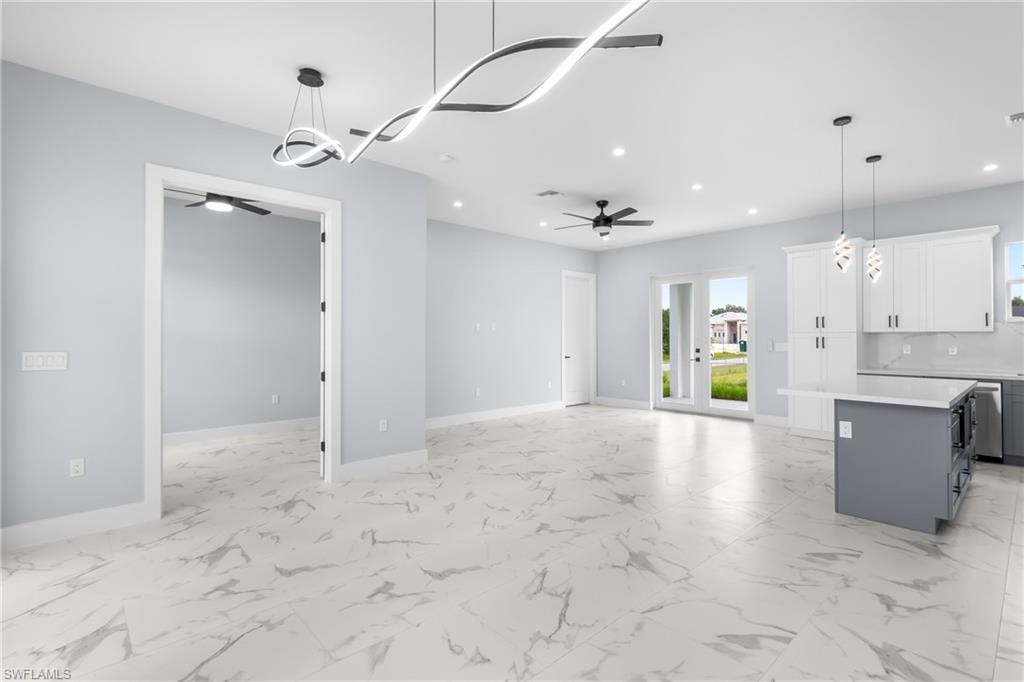 Unfurnished living room with light marble finish flooring and recessed lighting