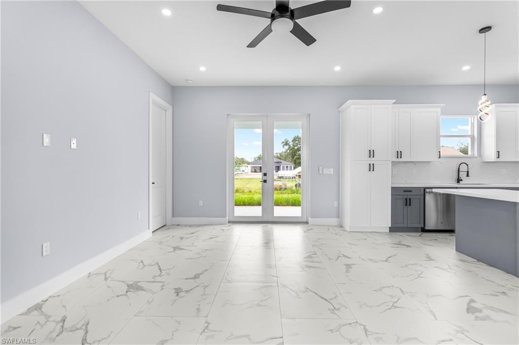 Unfurnished living room featuring light marble finish flooring, ceiling fan, recessed lighting, and french doors