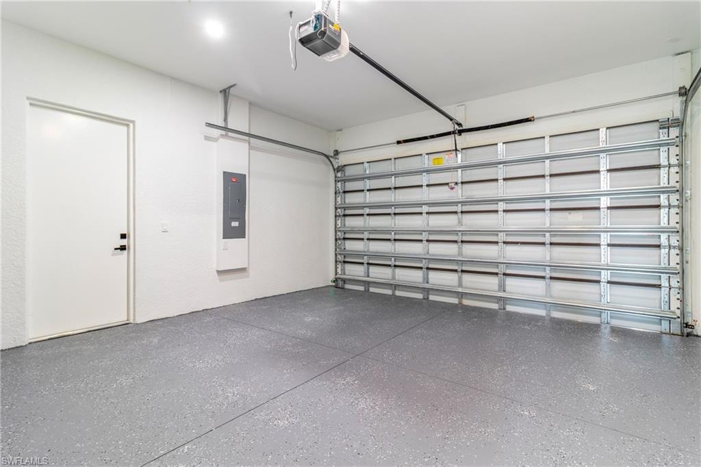 Garage featuring a garage door opener and electric panel